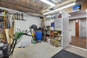 Garage packed with stored household items, tools and boxes on shelving