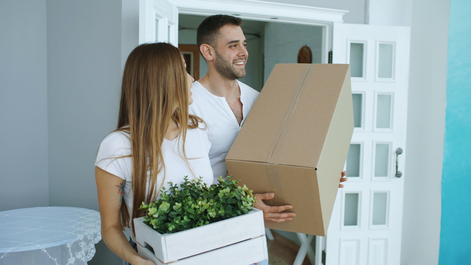 Couple in conversation surrounded by moving boxes while sharing out the work of a move
