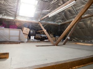 Loft space holding stored boxes and household items awaiting a clear-out before a move