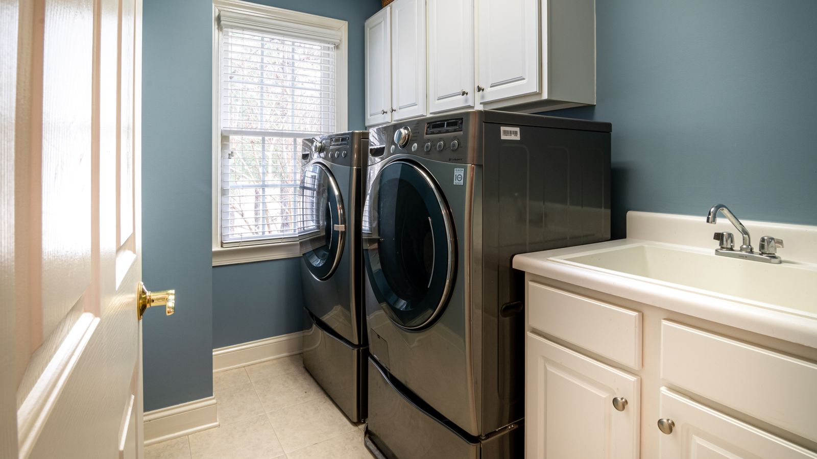 Utility room with a front loading washing machine plumbed in beside a worktop