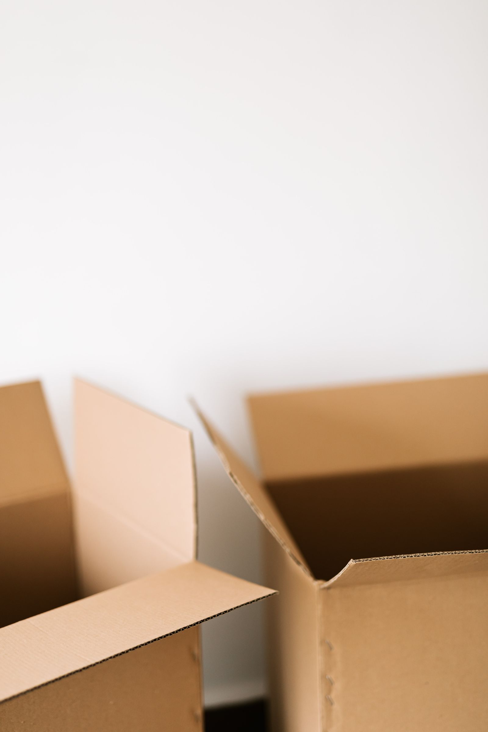 Open cardboard boxes on the floor of a bare room during a property clearance